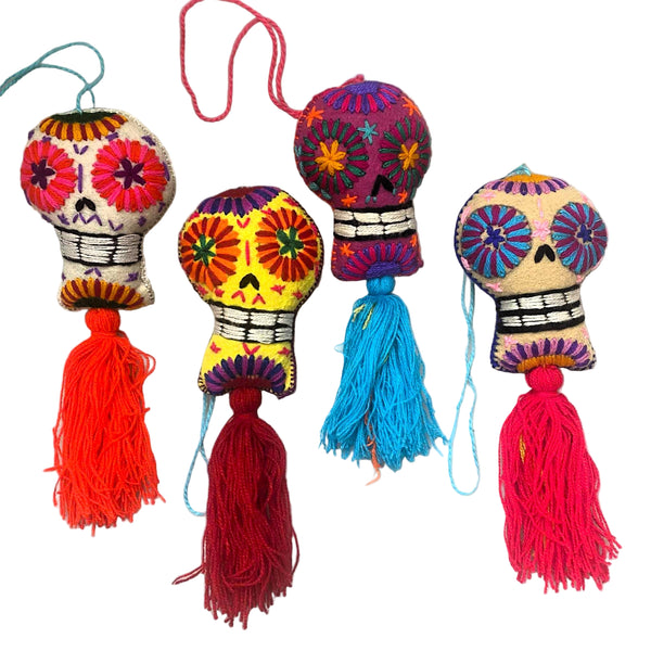 Colorful skull-shaped tassels with vibrant threads on a light gray background