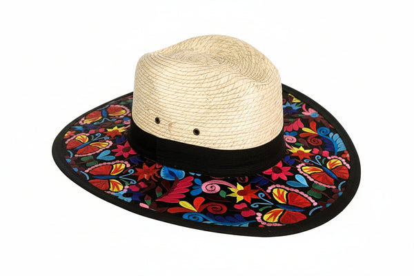Straw hat with a colorful embroidered black band on a white background
