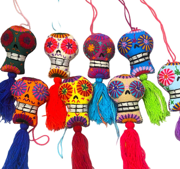Colorful decorative skull ornaments with tassels on a white background